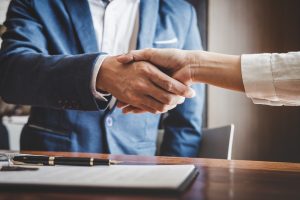 Commercial Real estate agent and customers shaking hands together celebrating finished contract after about home insurance and investment loan, handshake and successful deal