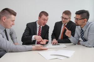 4 young professionals discussing business at a meeting table