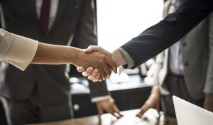 Commercial Real estate agent and customers shaking hands together celebrating finished contract