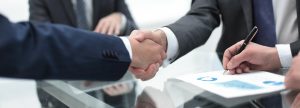 Commercial real estate agent and customers shaking hands after signing contract
