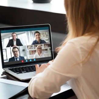 A woman on a video conference call with four other people