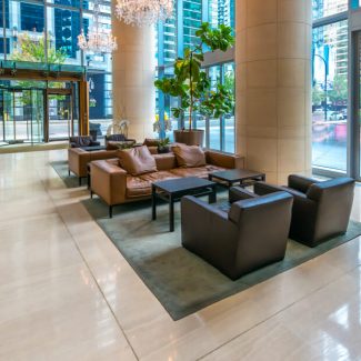 A clean empty first floor lobby area of an office with glass walls that provide views of outside