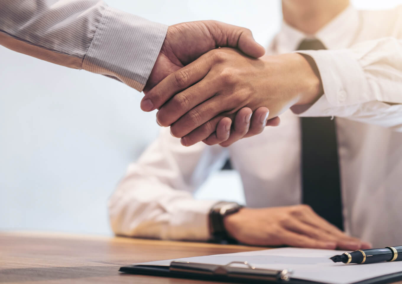 A realtor and client shake hands over a newly signed lease