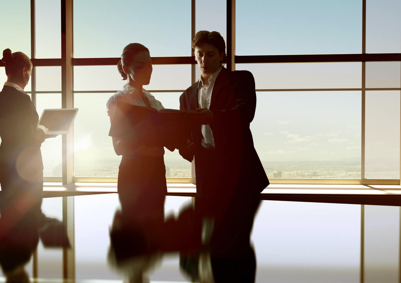 A realtor and client discuss a lease renewal in a brightly lit meeting room