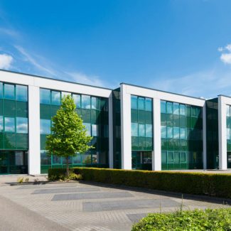 The exterior of an office building complex with glass wall windows