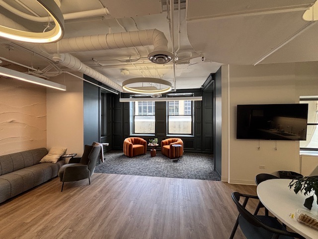 Collaboration area with a sofa, armchairs and a wall-mounted screen