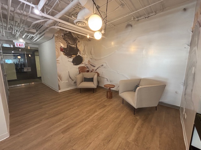 Entry and waiting area of Suite 2315 with lounge chairs against a marbled feature wall