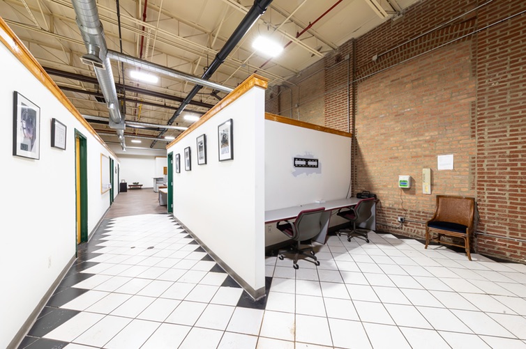 Corridor lined with private office doors, leading to a two-person work alcove
