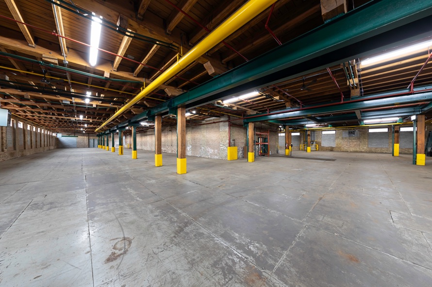 Long view down the warehouse floor showing the column spacing and clerestory windows