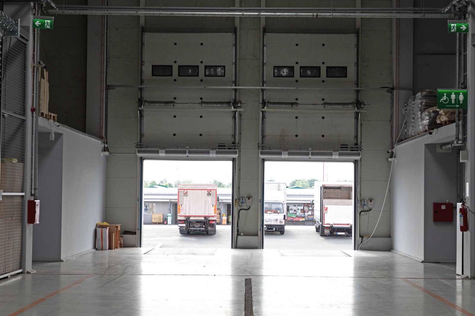 The inside of a warehouse looking out through open loading dock doors